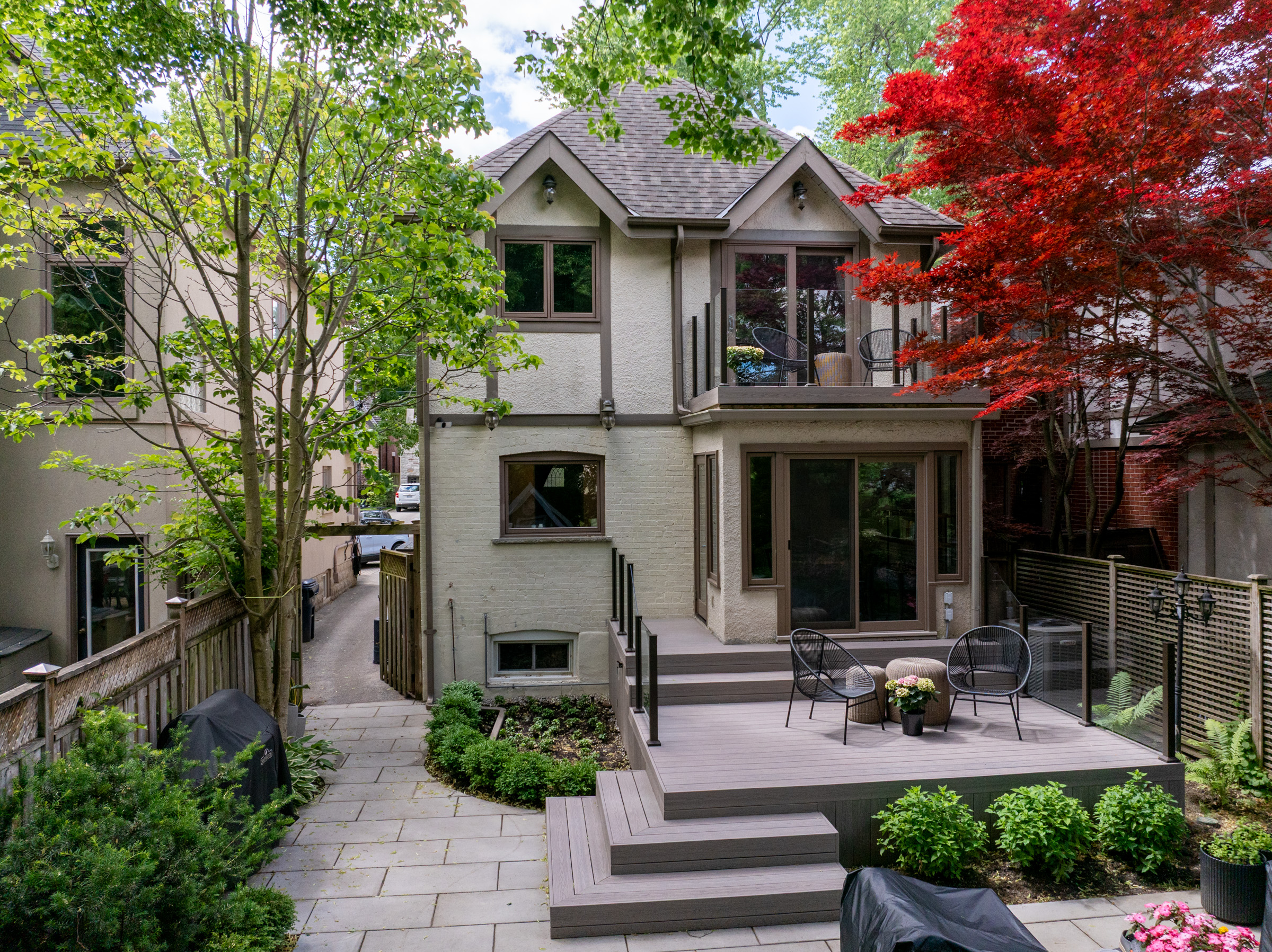 Wide view of the completed Fiberon Cabana backyard deck and rooftop deck with glass railings